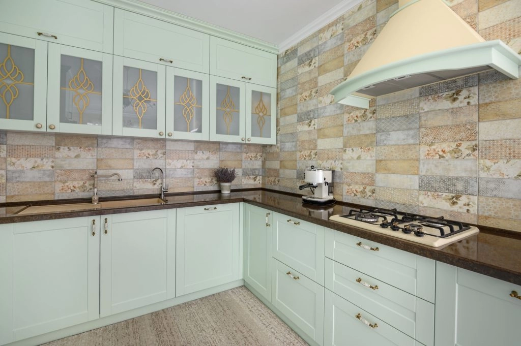Mint green kitchen cabinets with elegant glass panels and a stylish kitchen hood, perfect for holiday hosting.