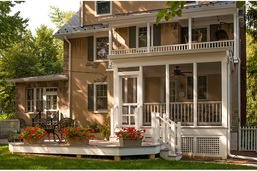 Charming screened porch with white railing, flower boxes, and seating, perfect for outdoor relaxation in Catonsville.