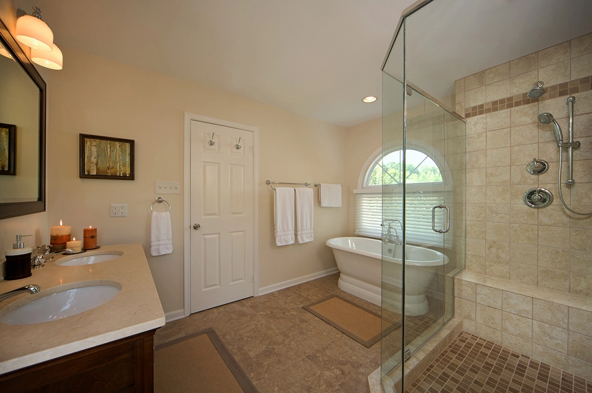 Modern bathroom featuring a glass shower, freestanding tub, and elegant fixtures for a luxurious feel.