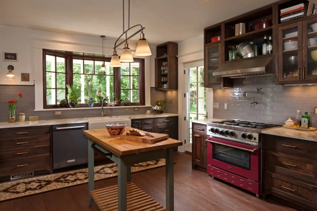 Modern kitchen featuring dark wood cabinets, a red gas range, and a central island, ideal for home remodeling projects.