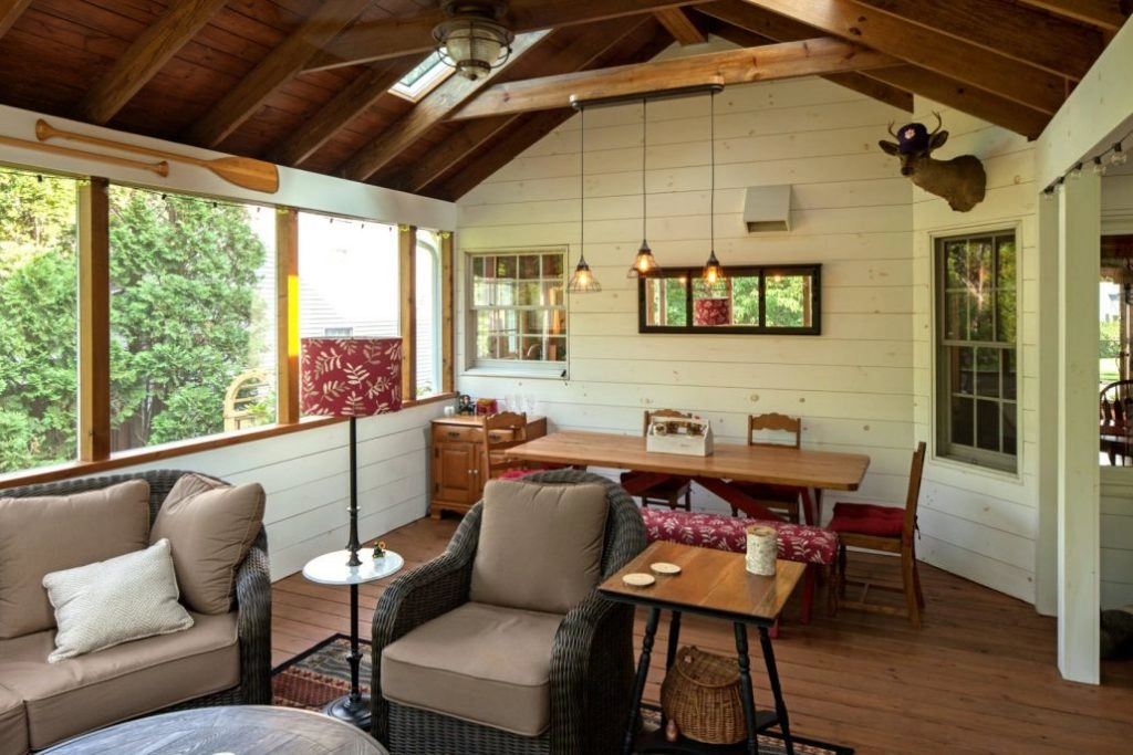 Cozy sunroom featuring wicker furniture, wooden ceiling, and large windows, ideal for house additions.