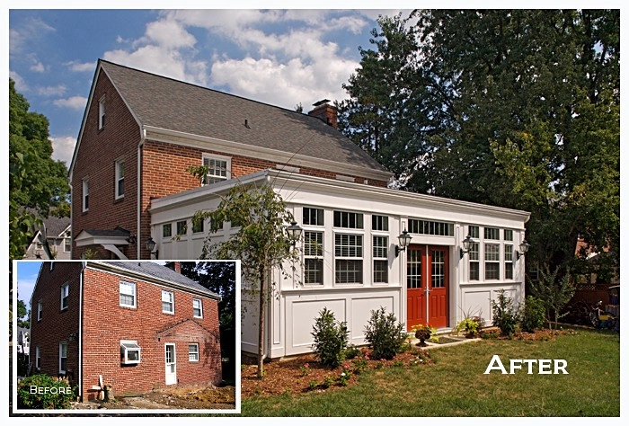 Beautifully remodeled home exterior featuring a new sunroom, white siding, and vibrant red double doors.